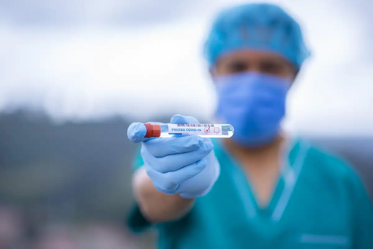 Flacoane mici cu probe de laborator aliniate pe un suport, văzute de aproape, pentru analize de sânge