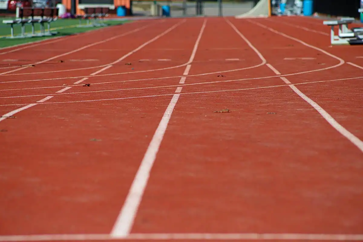 Pantofi de alergare așezați pe o pistă de atletism, pregătiți pentru efort și controlul medical sportiv