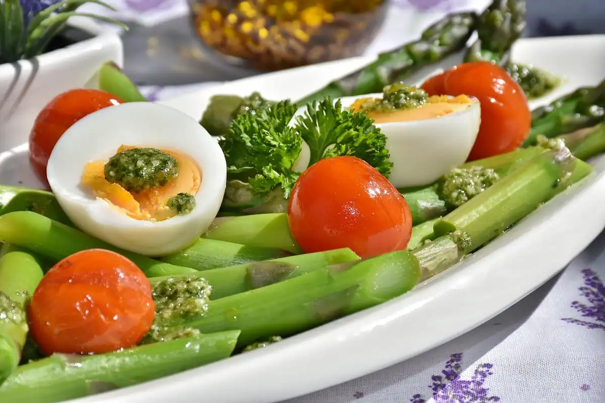 Farfurie cu sparanghel, ouă fierte, roșii cherry și pesto pentru o alimentație echilibrată