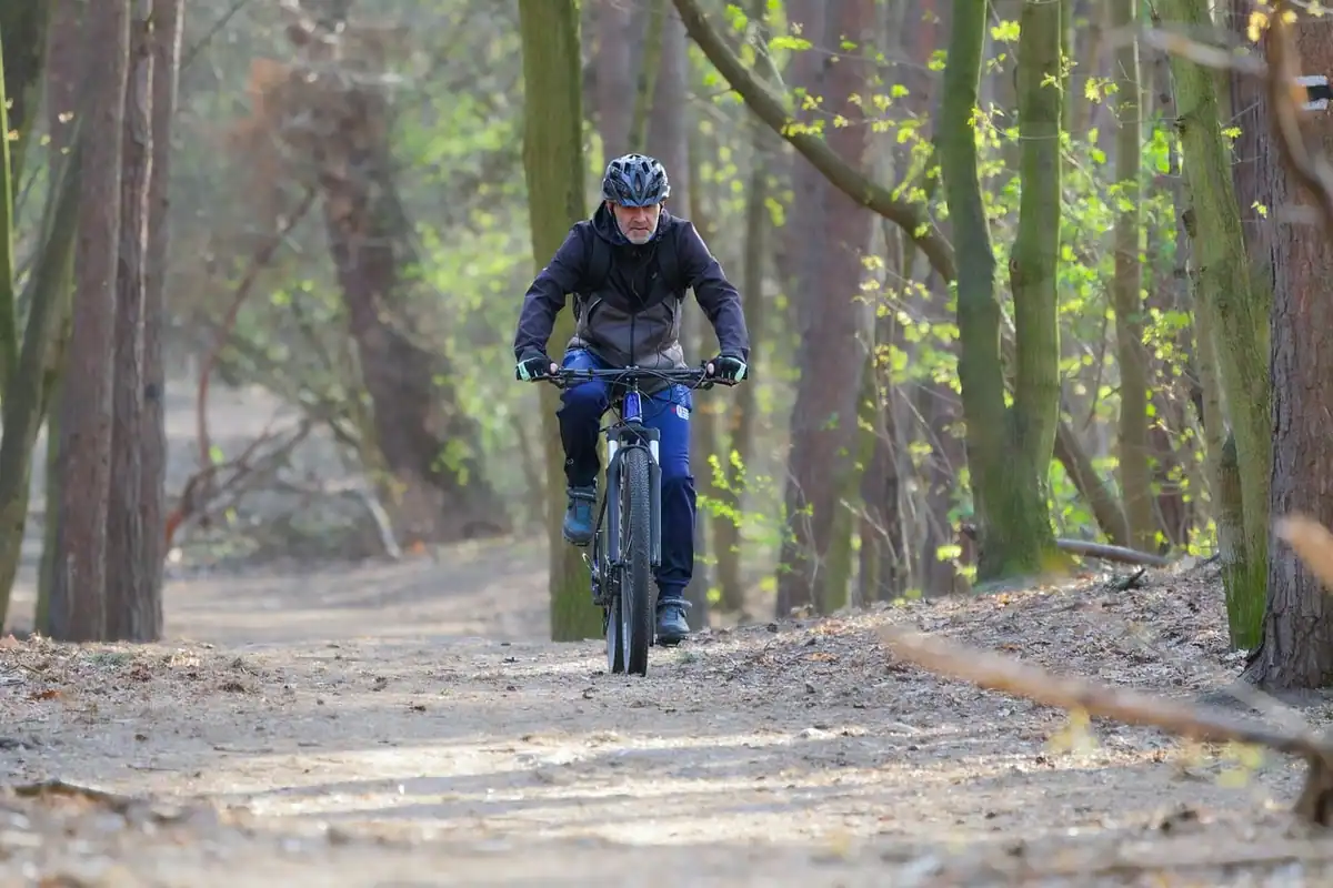 Ciclist cu cască pe o potecă de pădure, într-o zi de primăvară