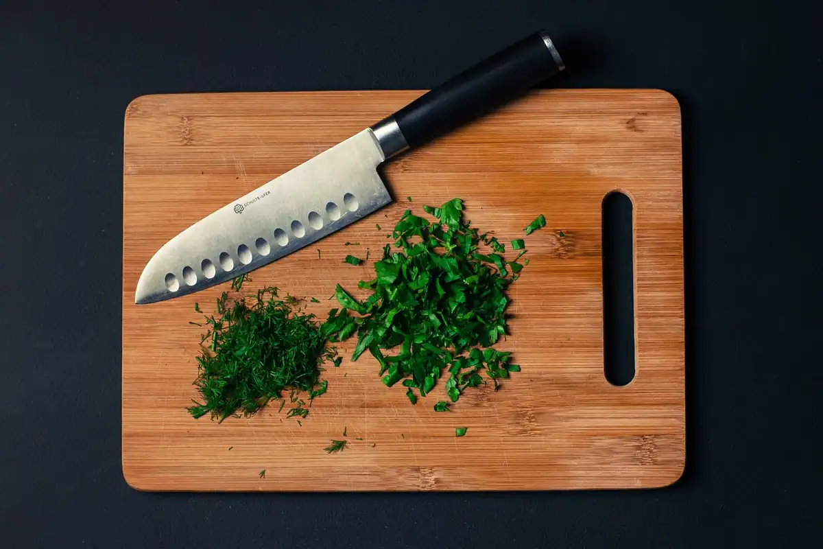 Ierburi aromatice proaspete tocate pe o tăietoare, alternativă la sare pentru gust în mâncare